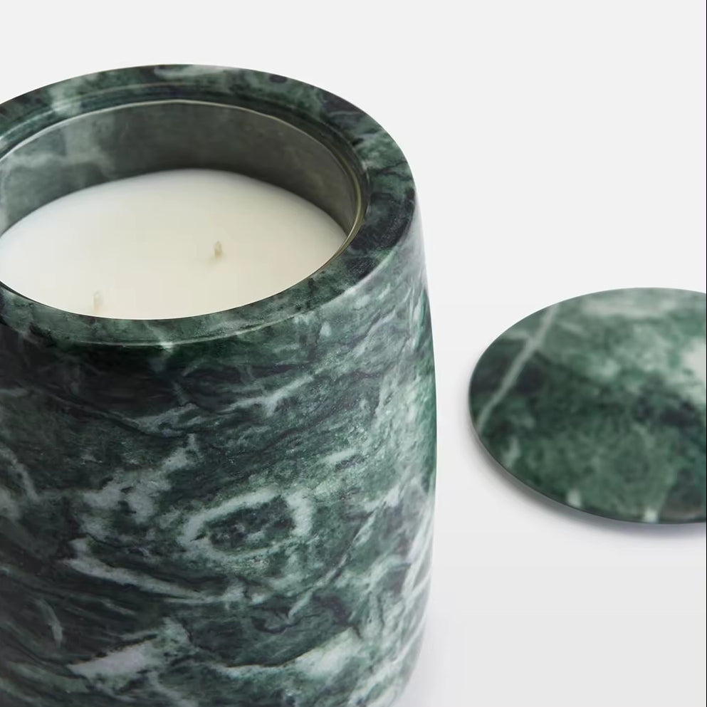 Marble-patterned candle holder with a candle inside on a white background